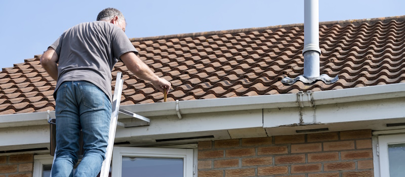 Man inspecting the roof of his home